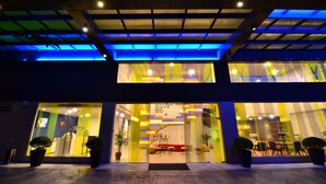 A modern building with a glass facade, a visible staircase, and potted plants at the entrance. - ibis Styles Kuala Lumpur Sri Damansara (Batu Caves)