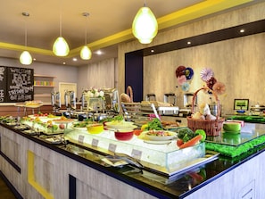 Un buffet proposant une variété de plats et un tableau noir sur lequel est écrit un message de bienvenue.