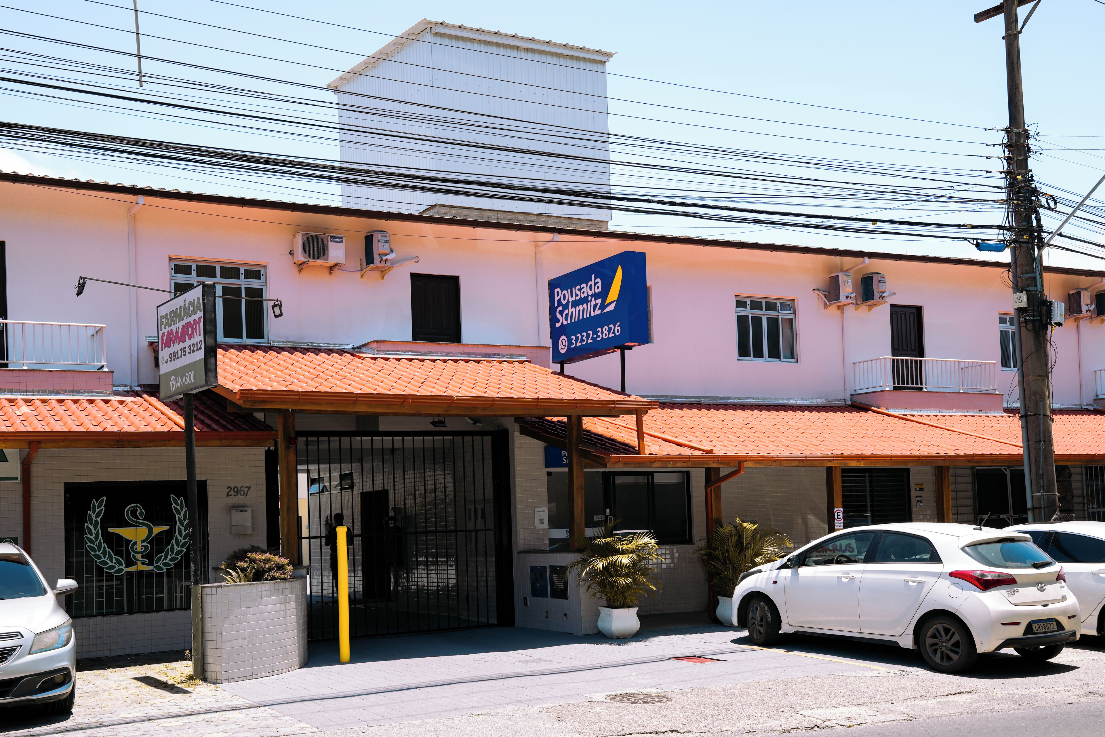 Un edificio con un letrero que dice 'Pousada Schmitz' y una entrada con portón.