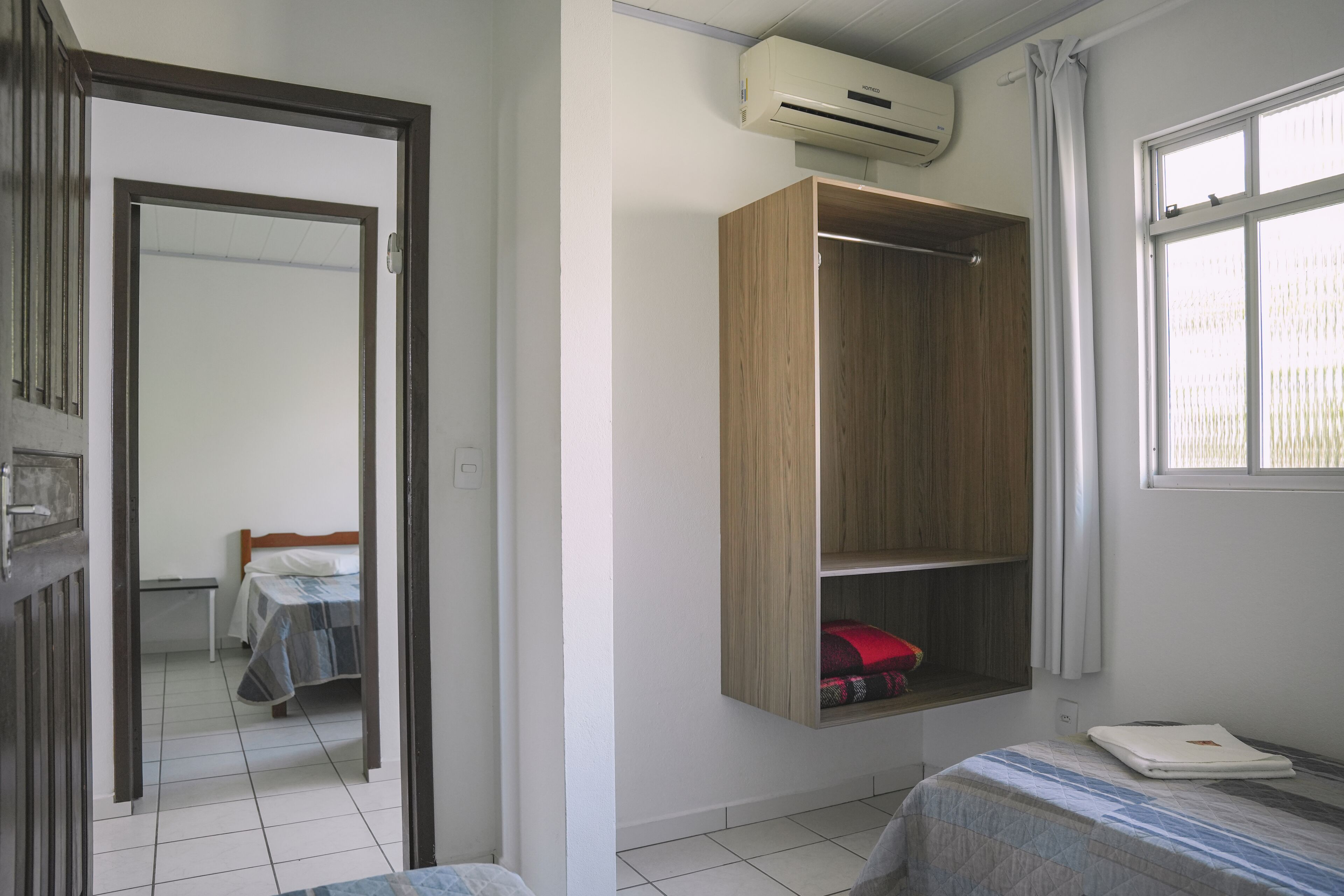 A bedroom with a bed, a wardrobe, and a window.