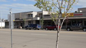 A street view with buildings, including a barber shop and a restaurant. - Morinville Plaza & Suites (Morinville)