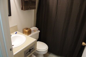 A bathroom with a white sink, toilet, and a shower curtain.