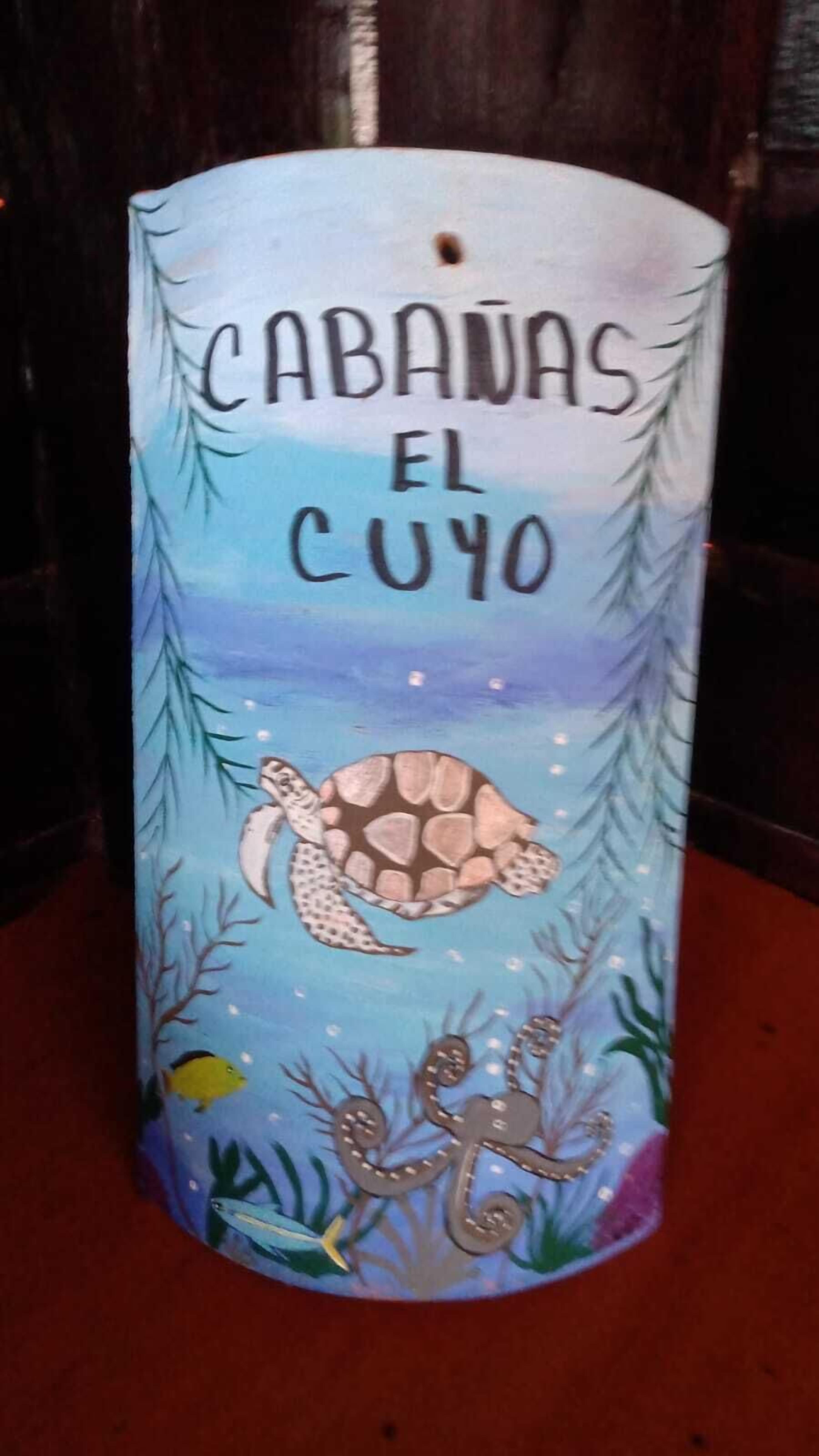 A candle with a sea turtle illustration and text 'CABAVAS EL CUYO'.