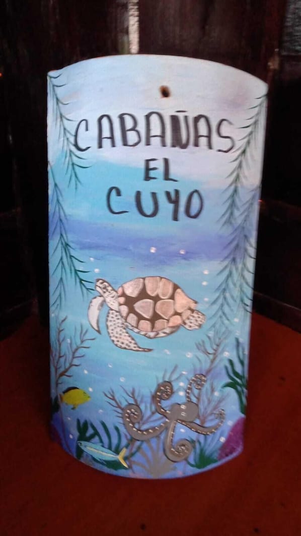 A candle with a sea turtle illustration and text 'CABAVAS EL CUYO'. - Cabañas El Cuyo (El Cuyo)