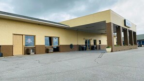 A building with a flat roof, a brick entrance, and a sign that reads 'Travel Inn.' - Travel Inn Marston I-55 by Hotel O (Marston)