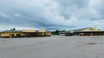 A Travel Inn and Hotel Suites with a large parking lot and a cloudy sky.