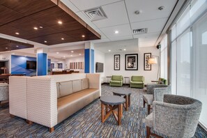 A hotel lobby with a seating area, a reception desk, and a large window. - Holiday Inn Express & Suites Dallas North - Addison by IHG (Dallas)