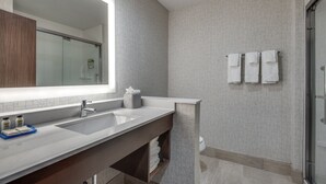 A modern bathroom with a large mirror, two sinks, and a glass shower enclosure. - Holiday Inn Express & Suites Dallas North - Addison by IHG (Dallas)