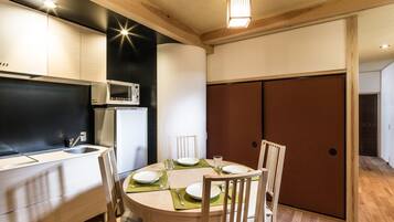 A modern kitchen with a dining area, featuring a microwave, sink, and wooden cabinets.