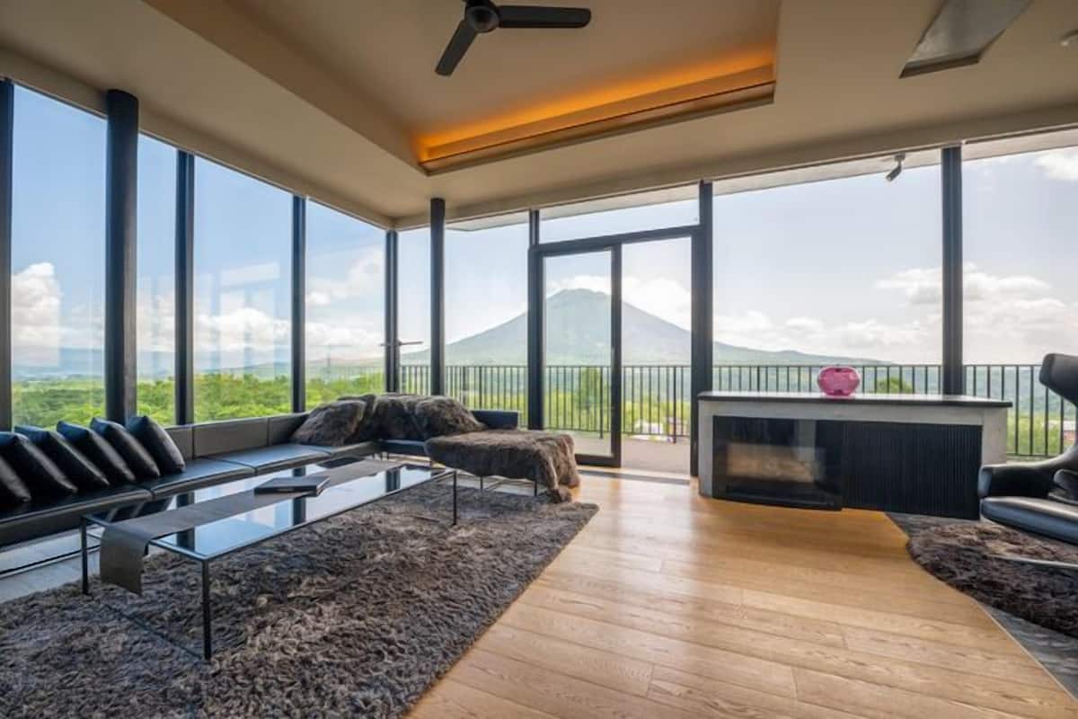 Una sala de estar moderna con un sofá, una mesa de centro y vistas a la montaña.