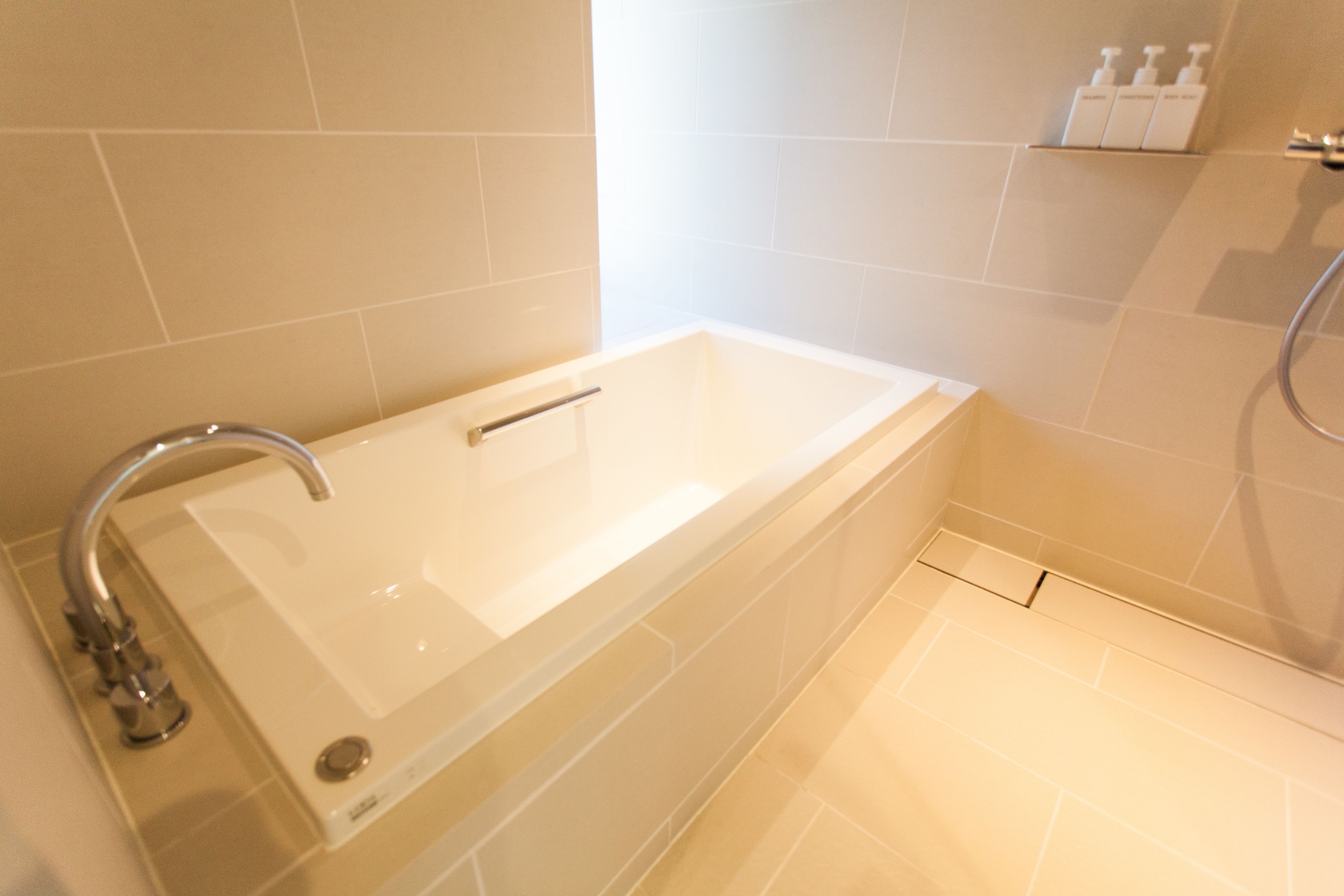 A modern bathroom with a bathtub, a shower, and a toilet.