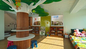 A children's playroom with a tree-themed ceiling, wooden shelves, and a bed with a colorful quilt. - Happy Together B&B (Wujie)