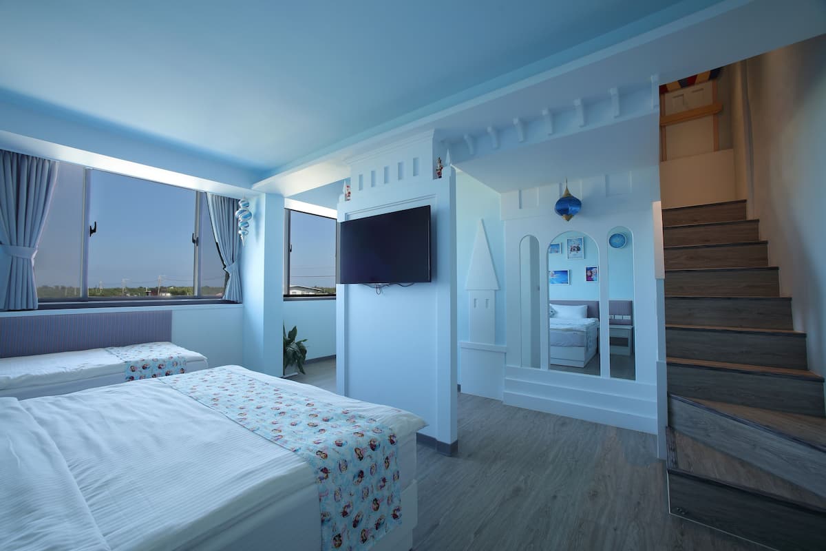 A hotel room with two beds, a TV, a staircase, and a view of the outside.