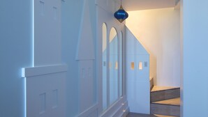 A hallway with a wooden floor, white walls, and a blue pendant light. - Happy Together B&B (Wujie)