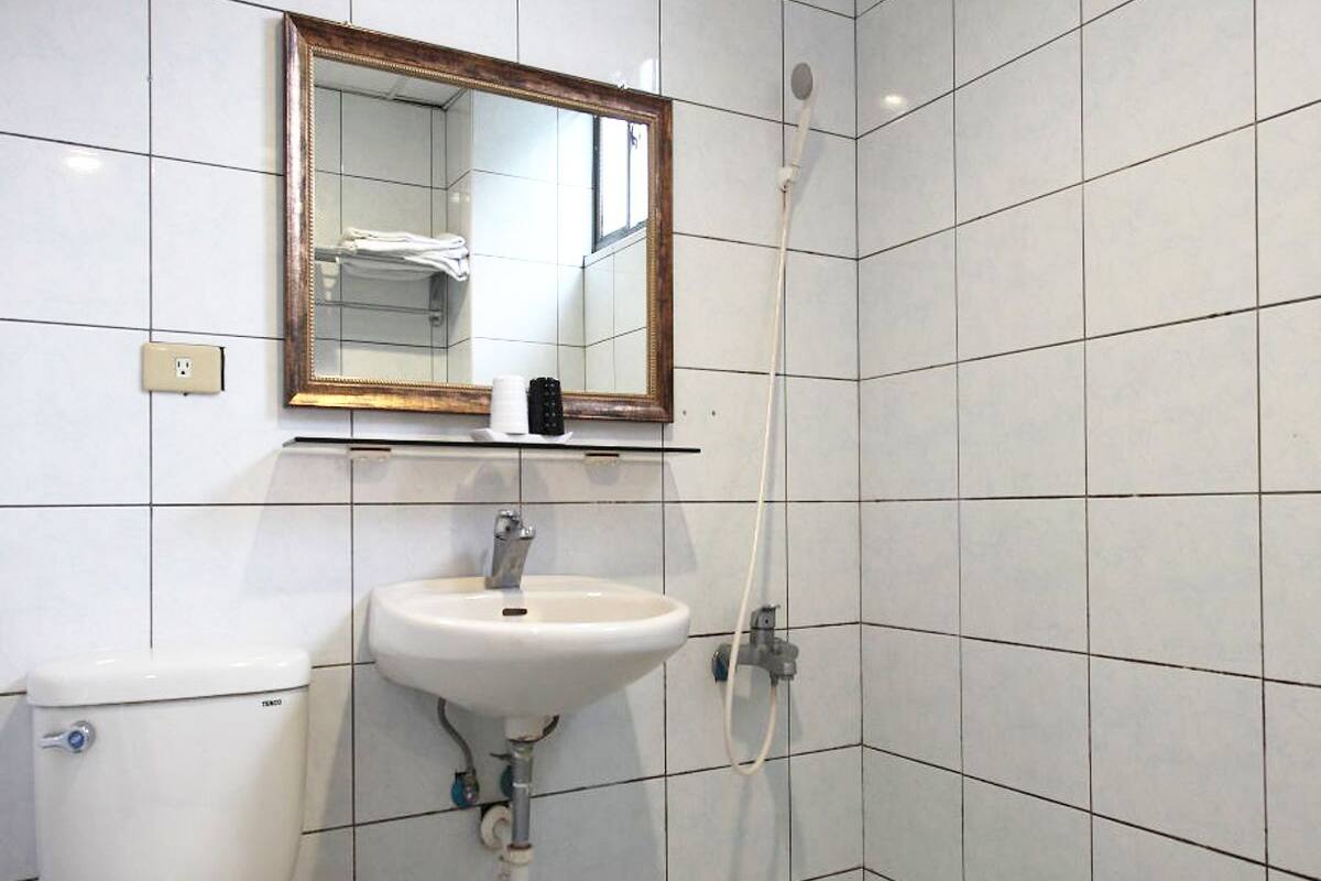 A small bathroom with a toilet, sink, and shower.