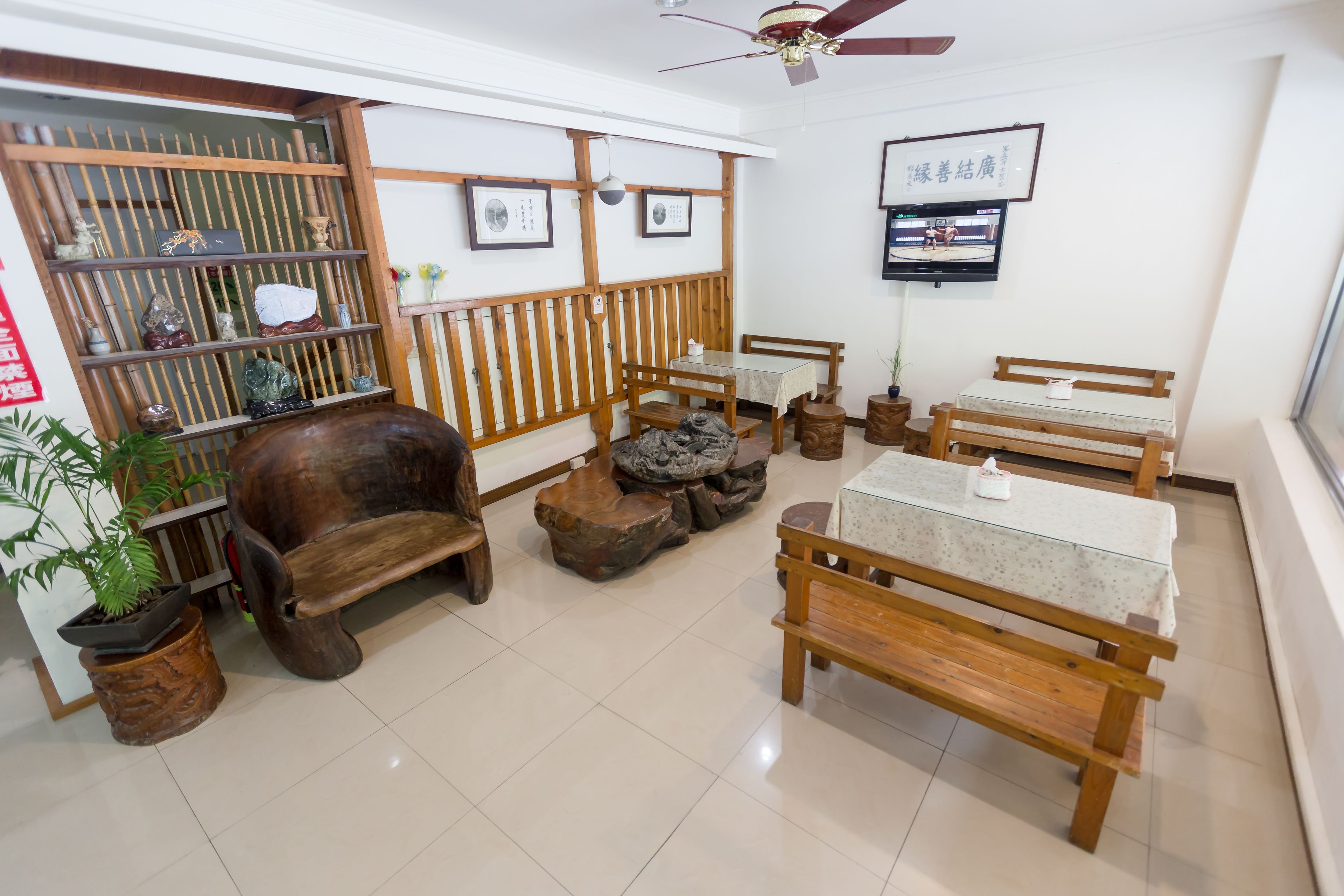 Habitación de estilo tradicional con muebles de madera, un televisor y un cartel en la pared.