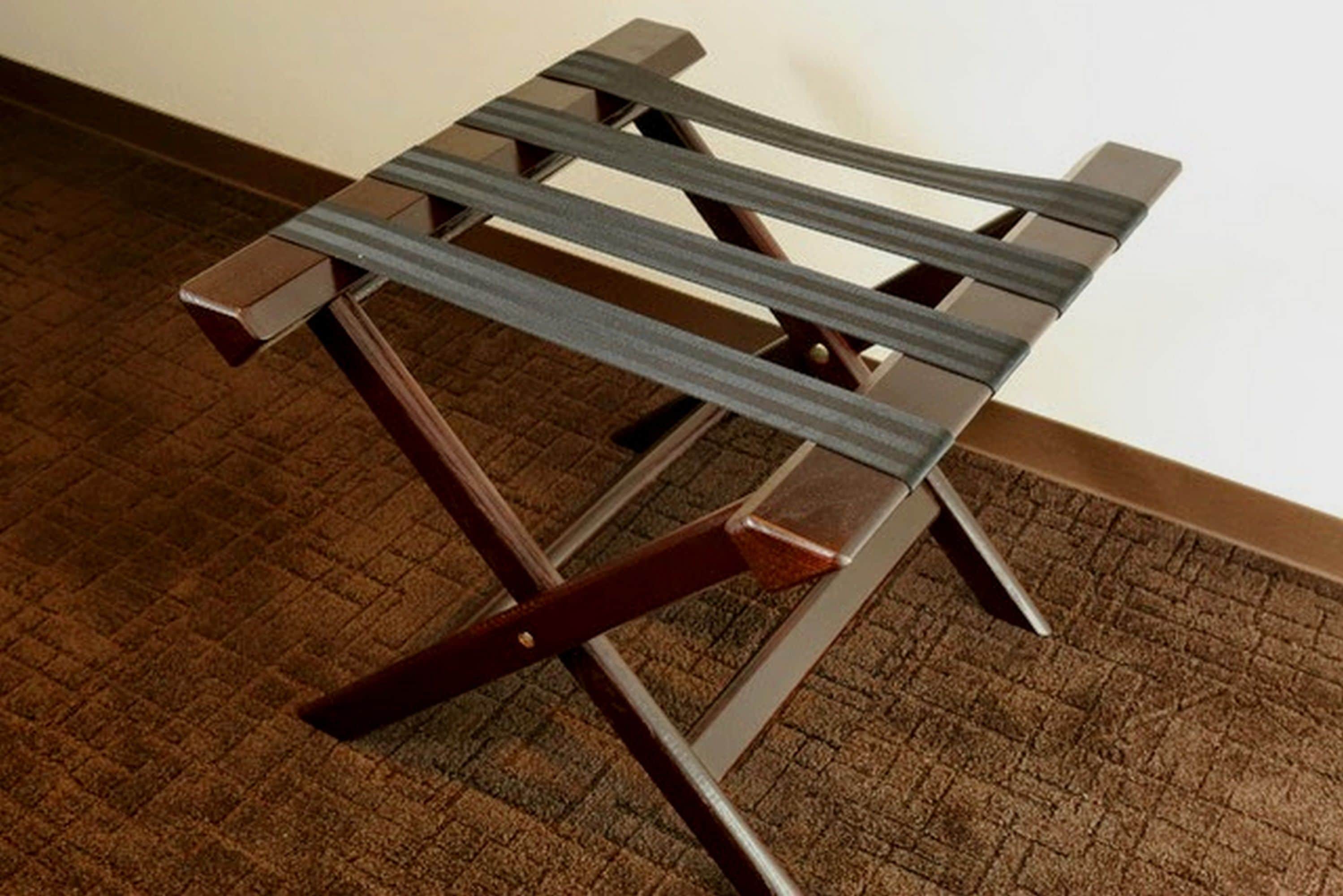 Une chaise en bois avec une structure en métal et un sol recouvert d’une moquette marron.