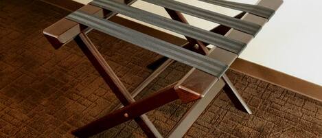 A wooden chair with a metal frame and a brown carpeted floor.