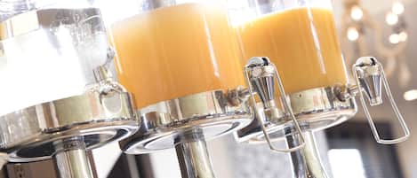 Un dispensador de jugo con múltiples grifos, cada uno con una bebida amarillenta.