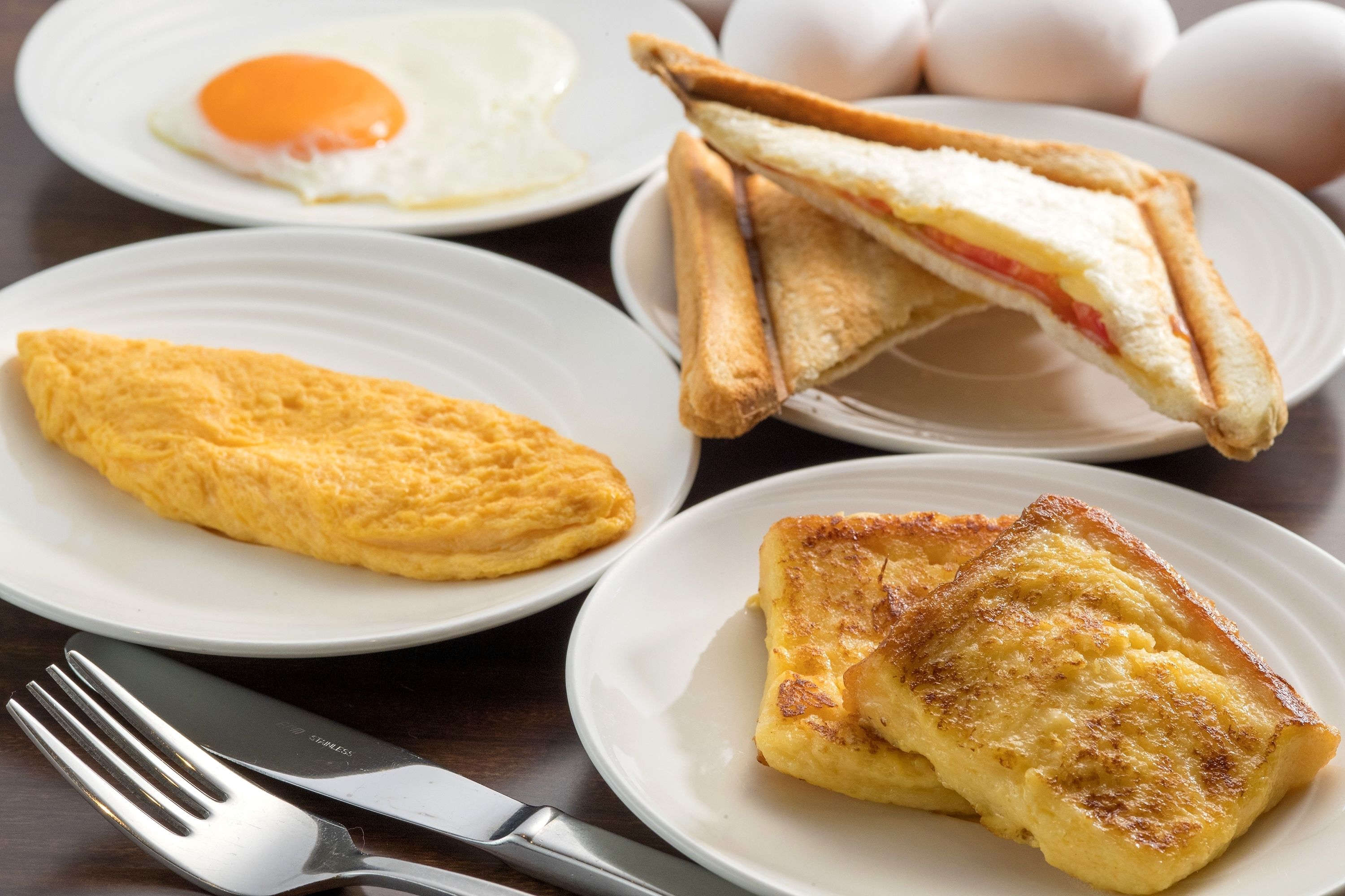 Desayuno con tostadas, un omelette y un huevo frito.