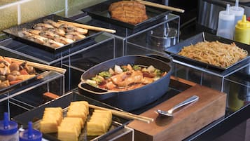 Een buffet met diverse gerechten, waaronder vis, tofu en groenten.