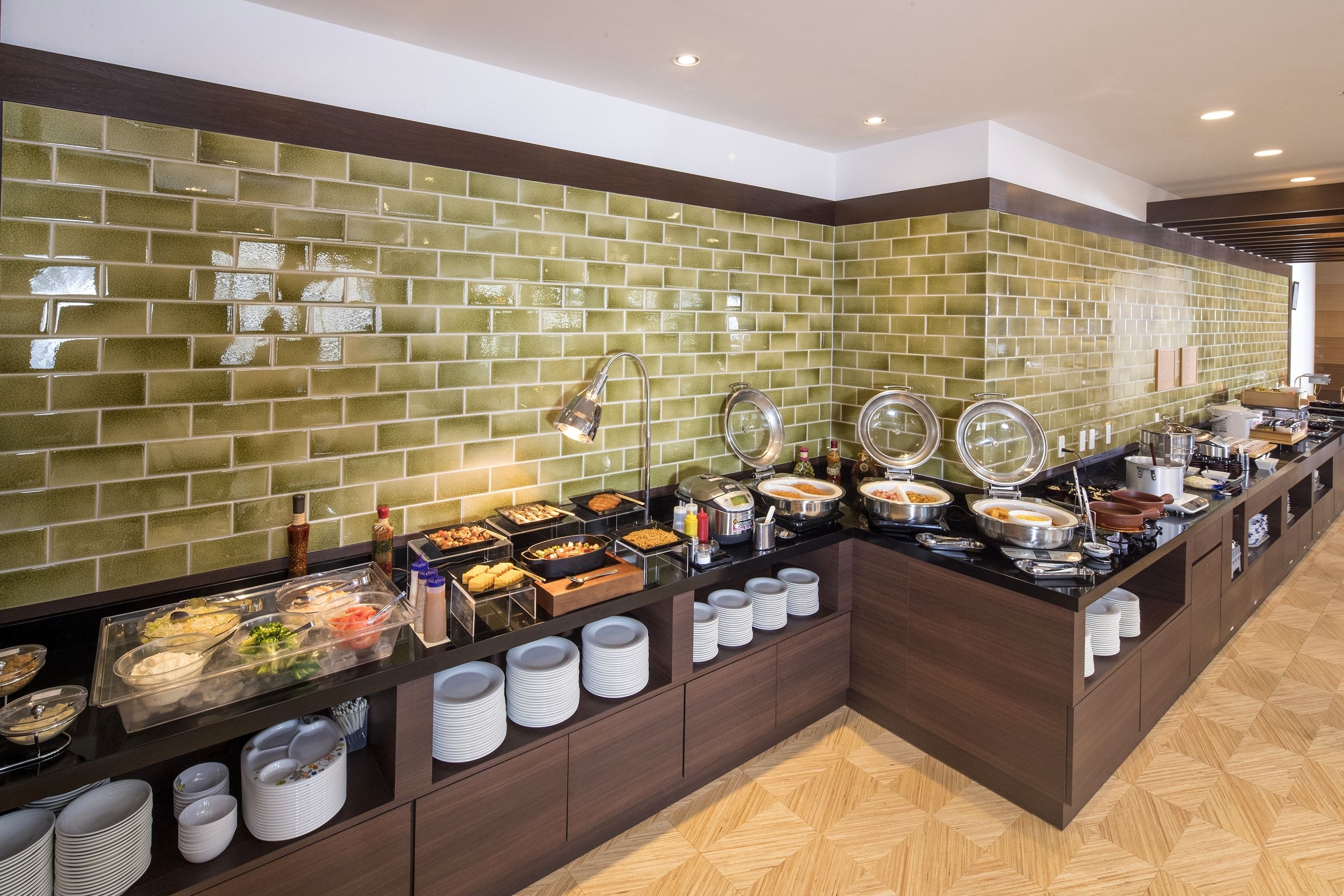 Un bufé con diversas opciones de comida y salsas, un respuesto de azulejos y piso de madera.