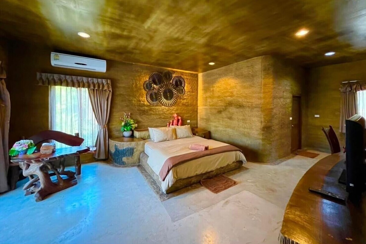 A bedroom with a large bed, a desk, and a chair.