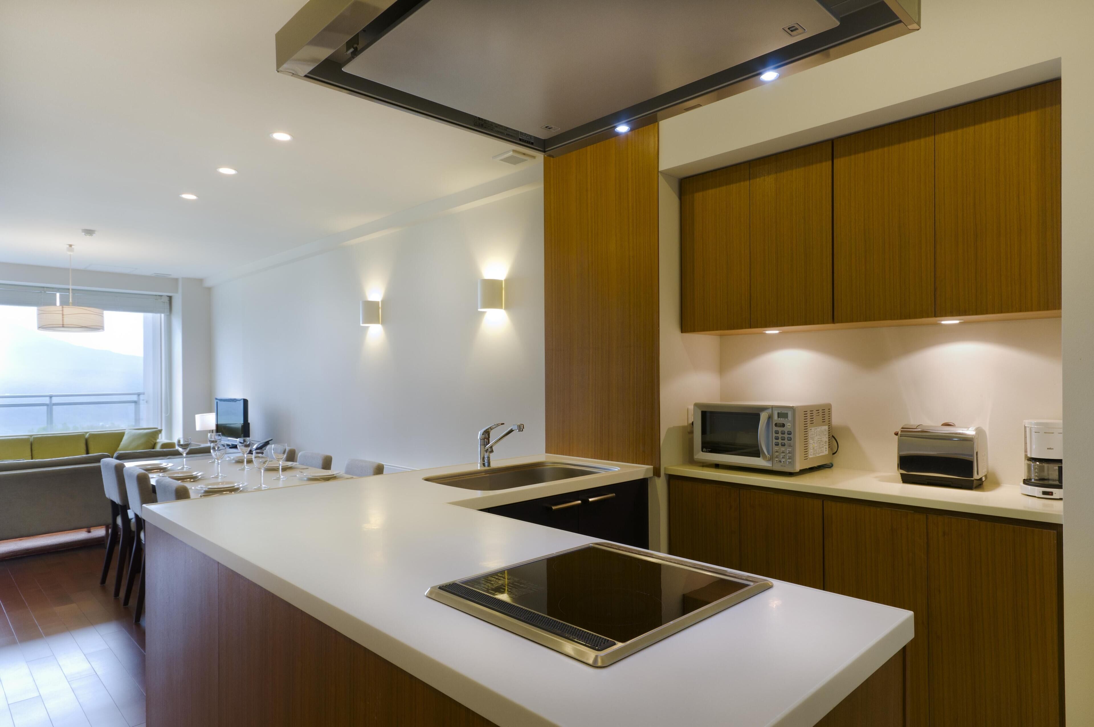 Una cocina moderna con una isla central, microondas integrado, tostadora y cafetera.