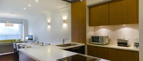 A modern kitchen with a central island, built-in microwave, toaster, and coffee maker.