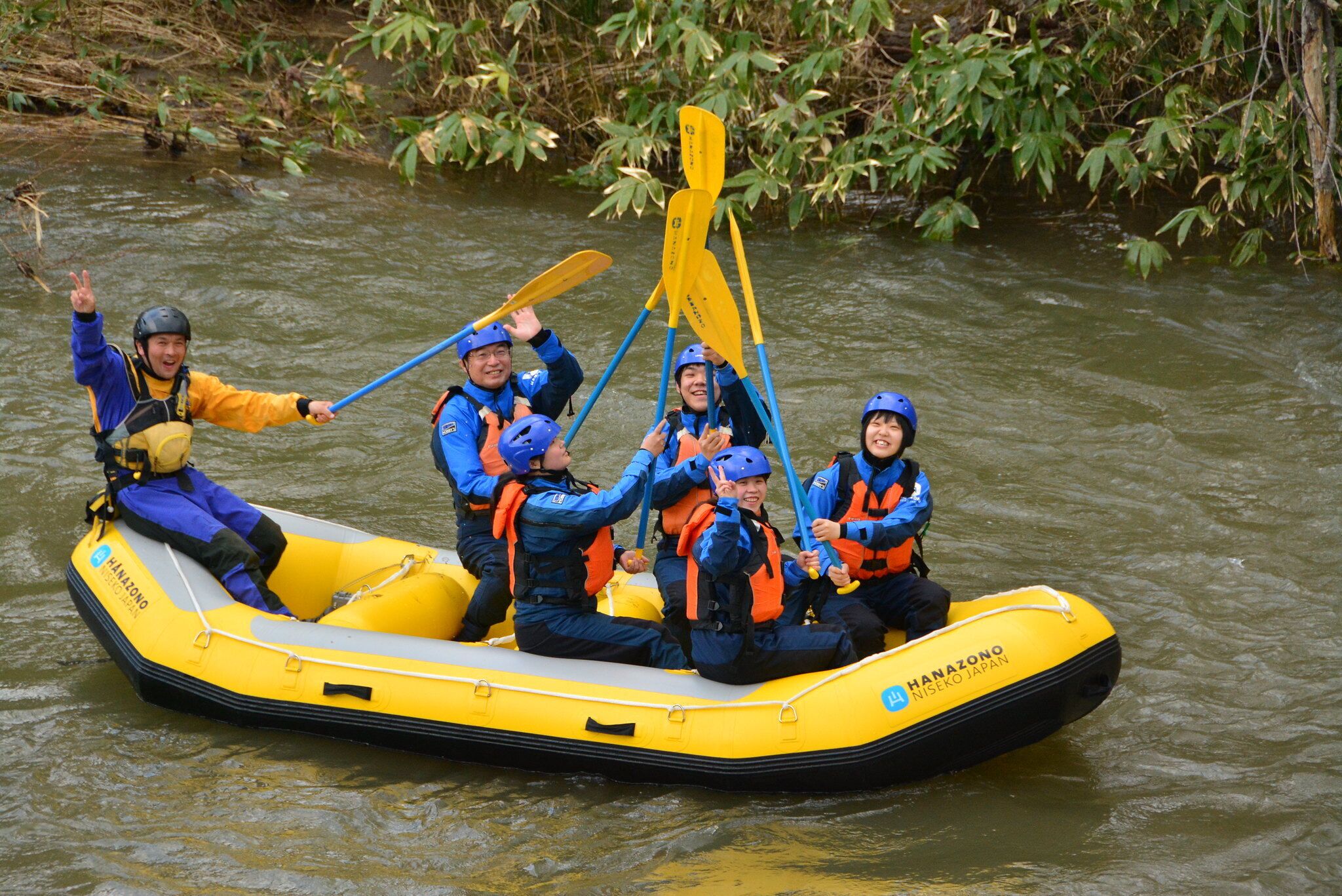 A group of people in a yellow inflatable raft on a river.