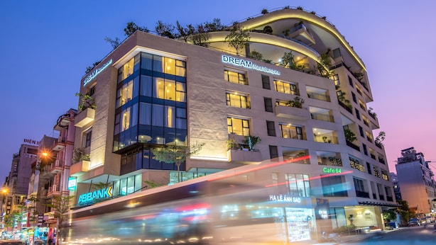 A multi-story hotel with a curved facade, balconies, and a cafe named Cafe 64. - Dream Hotel & Apartment (Hanoi)