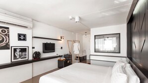 A modern hotel room with a large bed, a flat-screen TV, a wardrobe, and a window with curtains. - R1 Nimman Hotel Chiangmai (Chiang Mai)