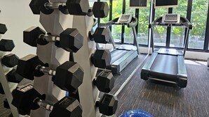 A gym with weightlifting equipment, treadmills, and large windows. - R1 Nimman Hotel Chiangmai (Chiang Mai)