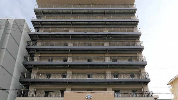 Um edifício de hotel com vários andares e uma placa chamativa no topo.