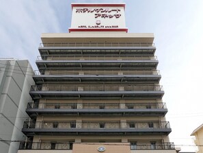 Un immeuble d’hôtel à plusieurs étages, surmonté d’une enseigne bien visible.