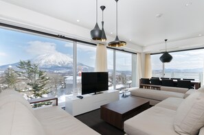 A modern living room with a large window, a flat-screen TV, and a sofa. - Kizuna (Kutchan)