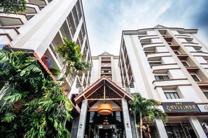 A modern hotel entrance with a prominent entrance canopy and a sign indicating a restaurant. - Phusuang Place (Chiang Mai)