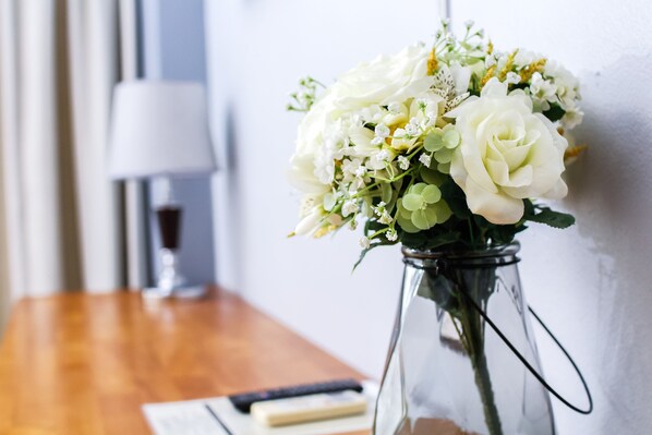 A clear view of a white flower arrangement in a glass vase on a wooden table. - Phusuang Place (Chiang Mai)