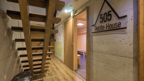A wooden staircase leading to a room labeled '505 Petite House'.