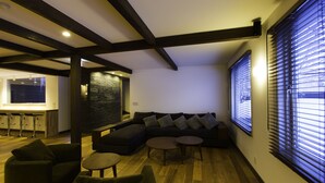 A modern living room with a sectional sofa, two round coffee tables, and a dark-colored couch.