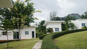 A residential area with white houses, a pathway, and well-maintained greenery. - WhiteRock Resort Pakchong (Pak Chong)