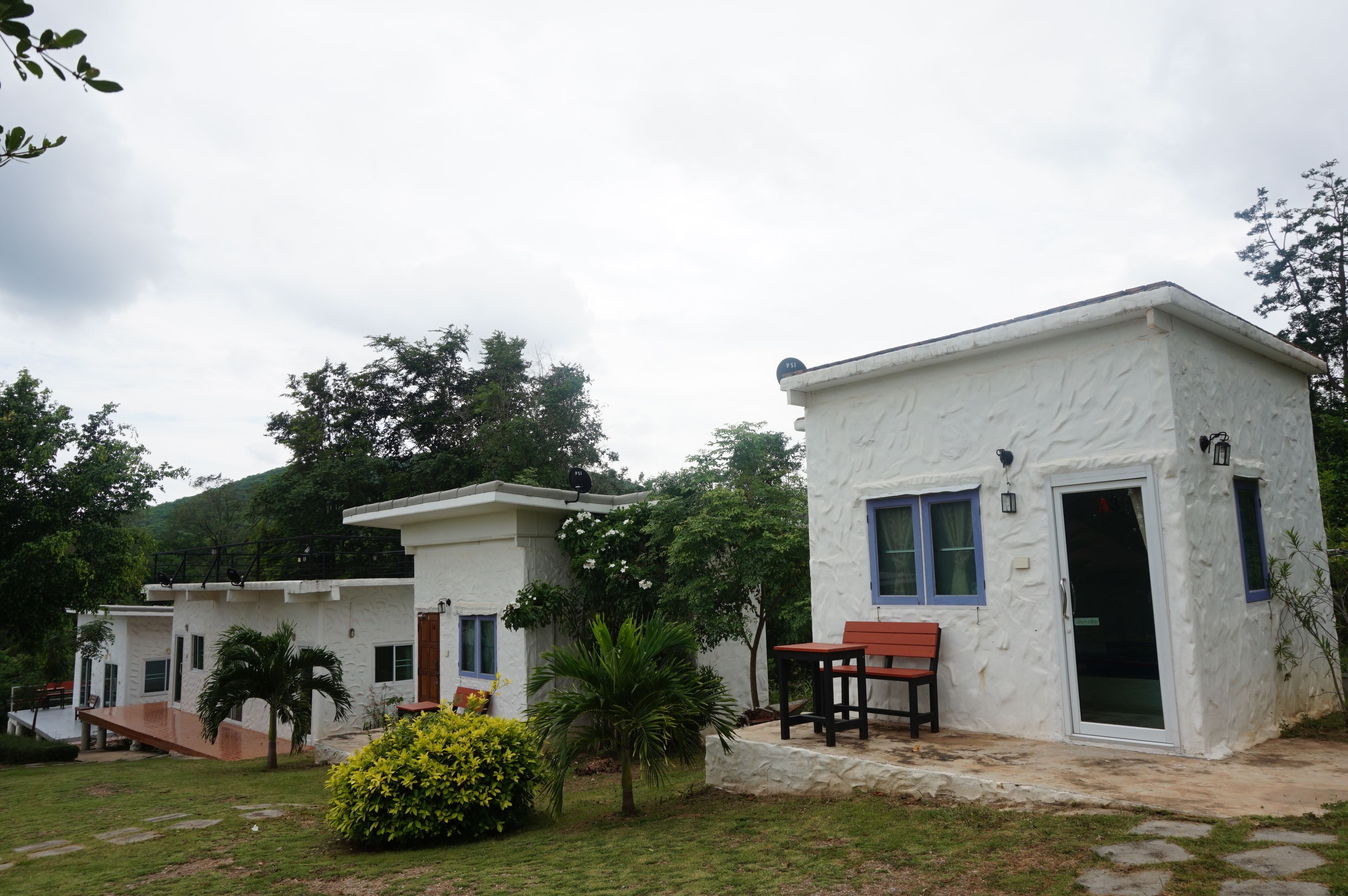 A white building with a small patio and a bench.