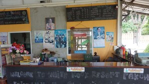 A reception area with a chalkboard sign, a menu board, and various posters. - WhiteRock Resort Pakchong (Pak Chong)