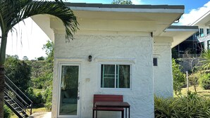 A white building with a bench, a door, and a window. - WhiteRock Resort Pakchong (Pak Chong)