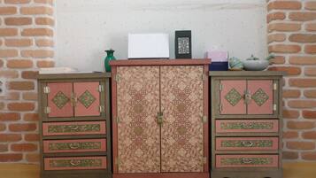 Una habitación modelo con dos armarios de madera, una mesita y un florero.