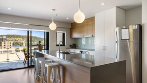 Una cocina moderna con una isla grande, electrodomésticos de acero inoxidable y vistas a la ciudad.