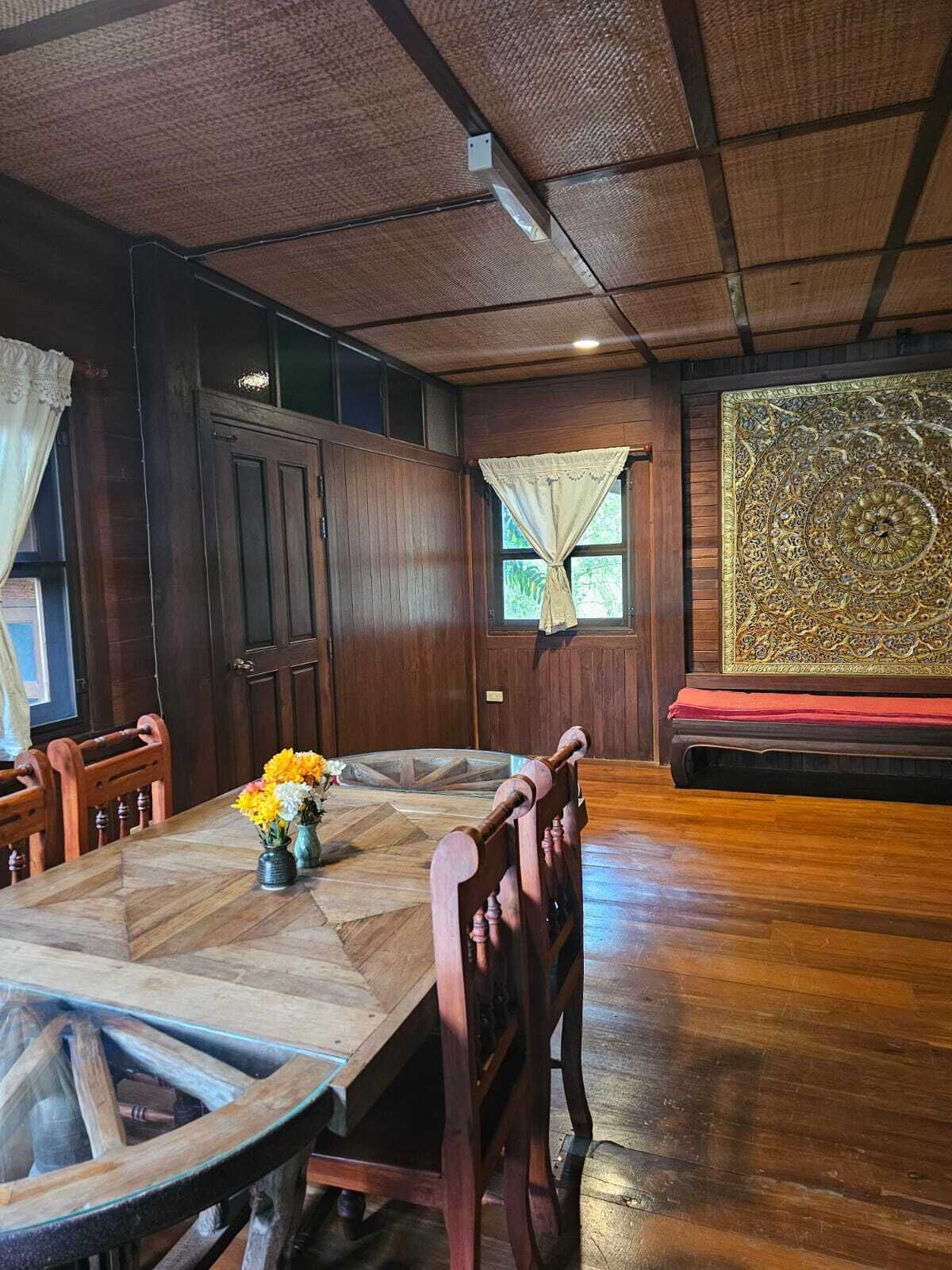 Een eetruimte met een houten tafel, stoelen en een decoratief vloerkleed.