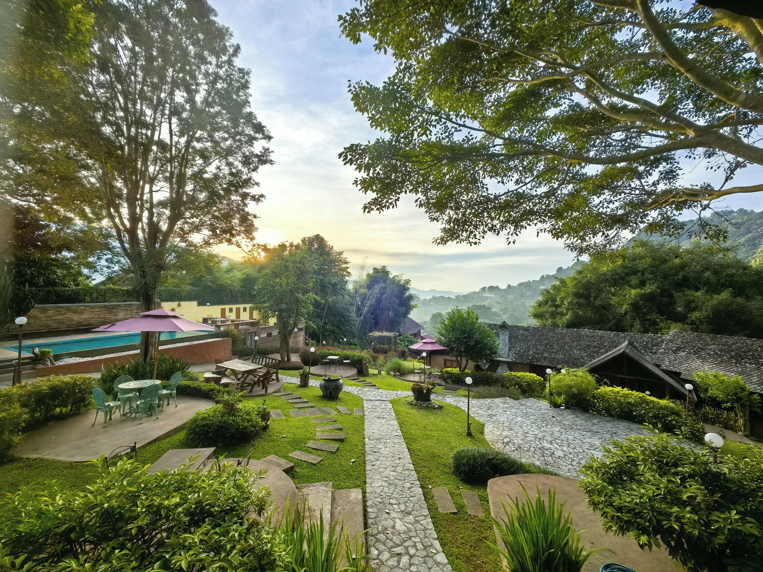 Um jardim com piscina, área de estar ao ar livre e um caminho de pedra.