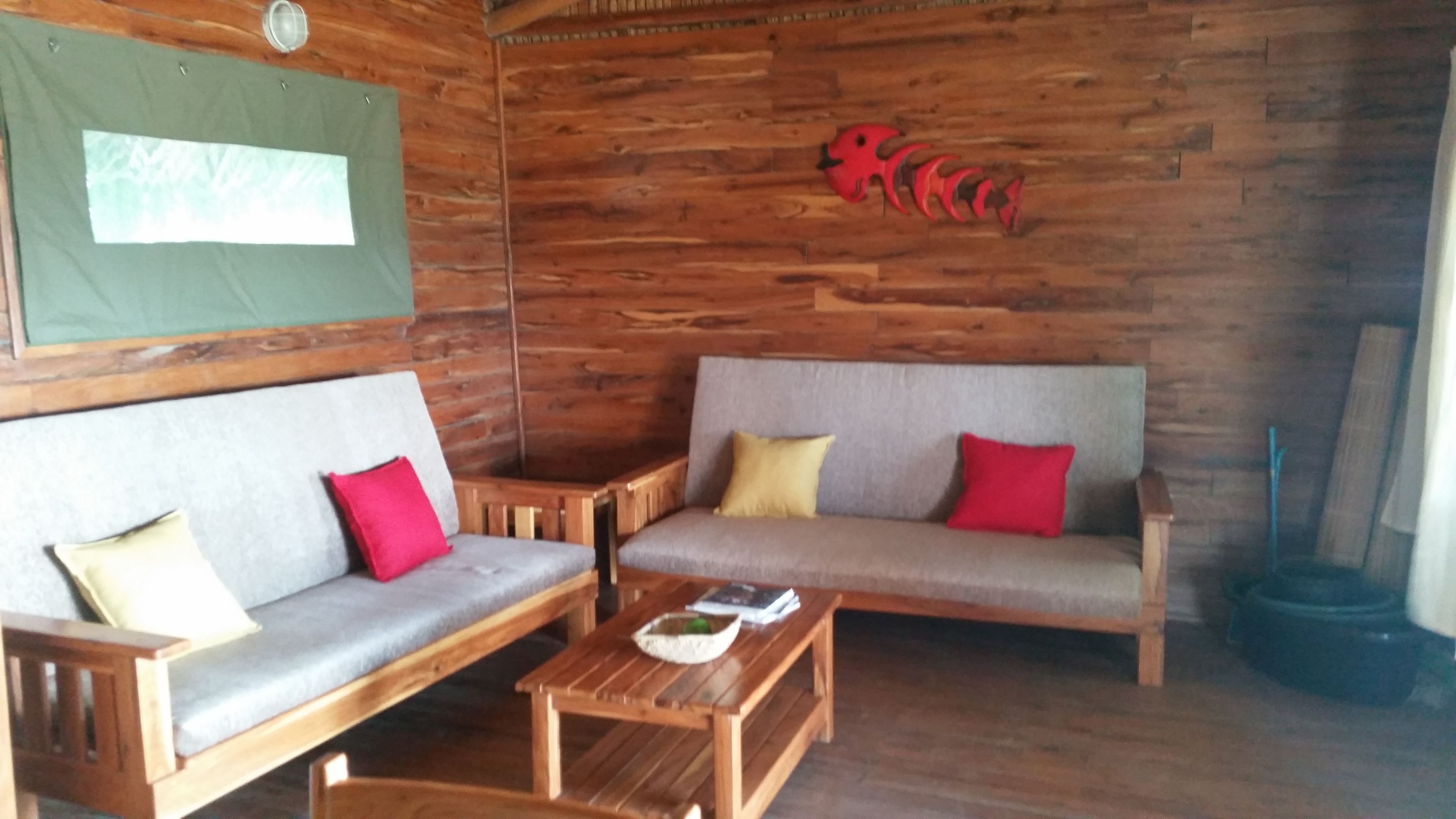 A wooden interior with two sofas, a coffee table, and a wall-mounted decoration.