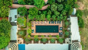 An aerial view of a resort with a central swimming pool, surrounded by lush greenery and a variety of outdoor seating areas. - Model Residence and Spa (Siem Reap)